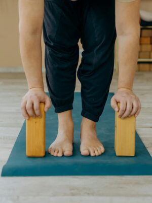 A person practicing yoga using blocks on a mat indoors, focusing on balance.