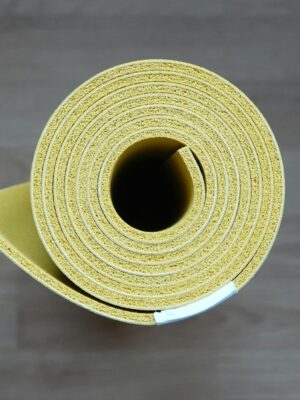Close-up of a rolled yellow yoga mat, ideal for fitness enthusiasts and interior design.