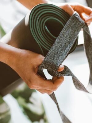 Close-up of a woman's hands holding a yoga mat with a strap. Perfect for fitness and lifestyle concepts.